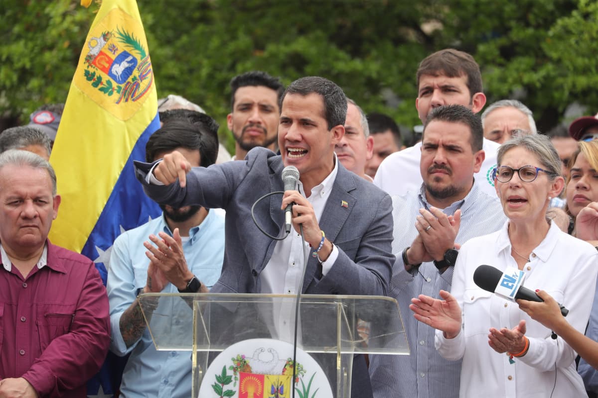 Juan Guaidó puhuu taustallaan kannattajia ja Venezuelan lippu.