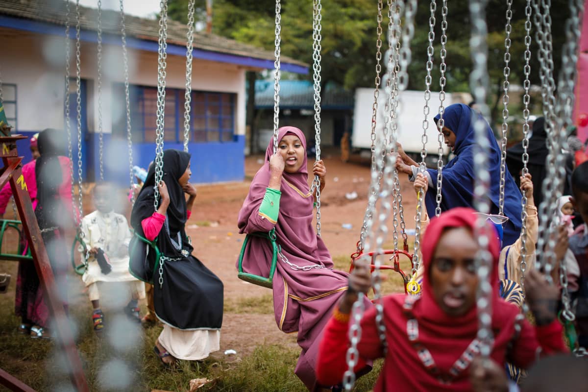 Tytöt kokeilevat keinuja nairobilaisen koulun pihalla kesäkuussa 2019. Maaseudulla monen tytön koulutaival katkeaa
kuukautisten alkamiseen.