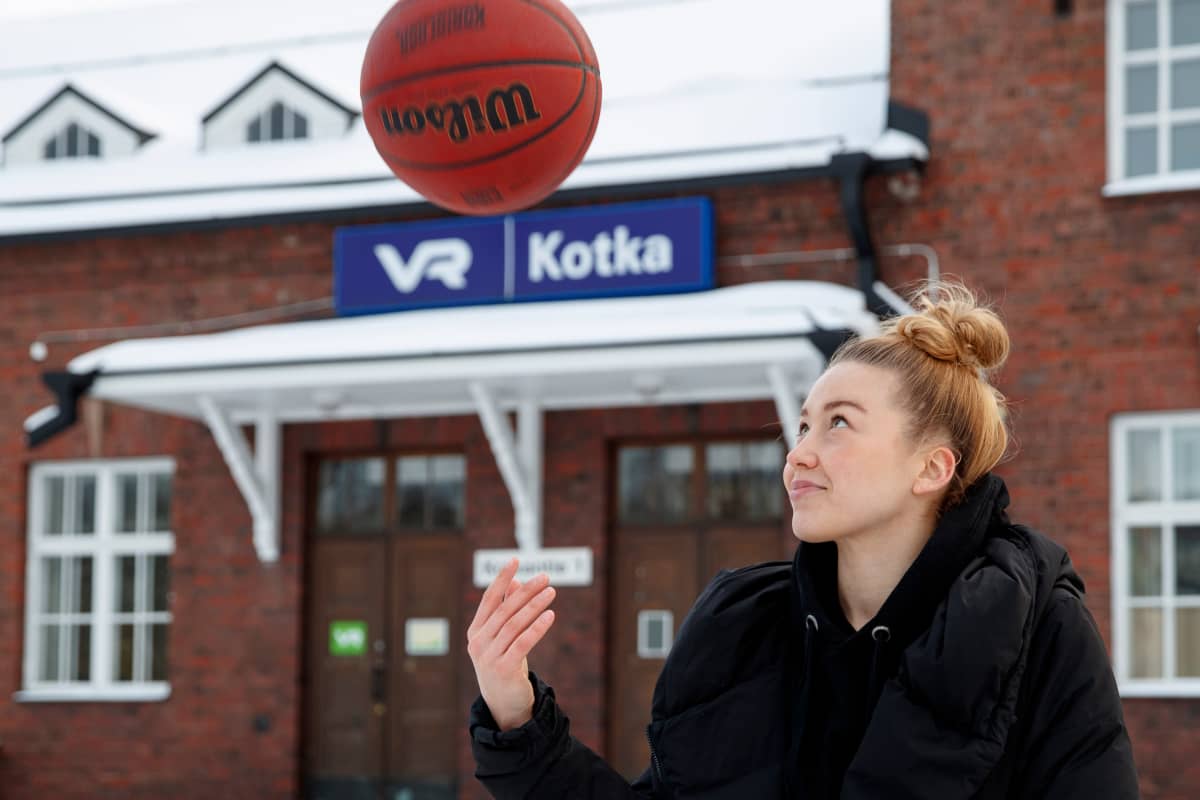 Linda Lehtoranta poseeraa koripallon kanssa Kotkan juna-asemalla. 