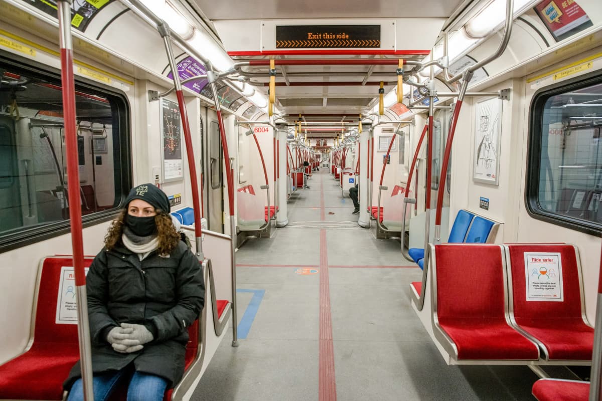 Nainen yksin metrovaunussa Toronton metrossa