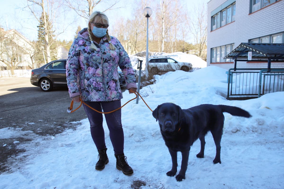 Erja Kulmala ja hänen koiransa Laku Kouvolan eläinsairaalan pihalla.