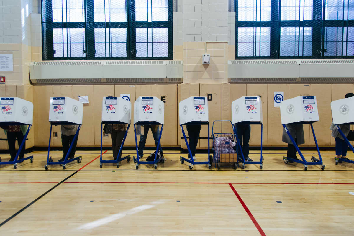 Äänestäjät ovat kopeissaan sermien takana Yhdysvaltain vaaleissa 2016.