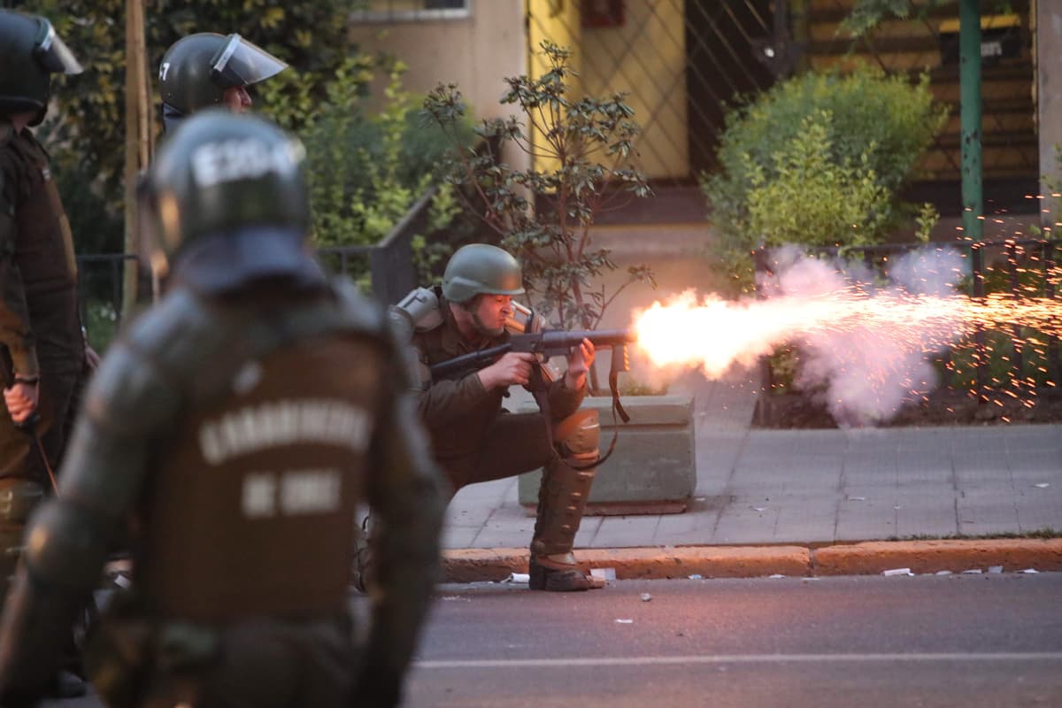 Poliisi ampuu kyynelkaasua Santiagossa Chilessä.