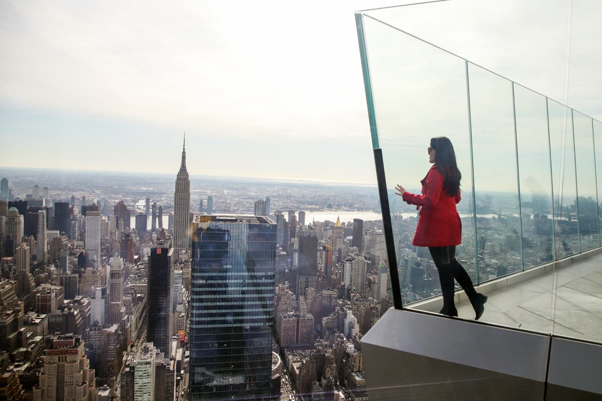 Nainen katsoo maisemaa pilvenpiirtäjän näköalatasanteella New Yorkissa.