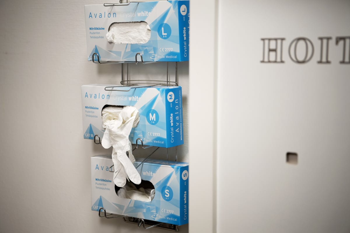 Pakkauksissa olevia kertakäyttöisiä suojakäsineitä sairaalan potilashuoneessa.