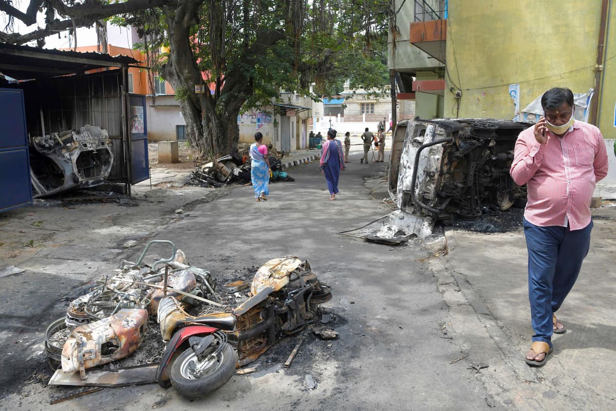 Mellakoissa tuhoutuneita ajoneuvoja kadulla Bengalurussa.