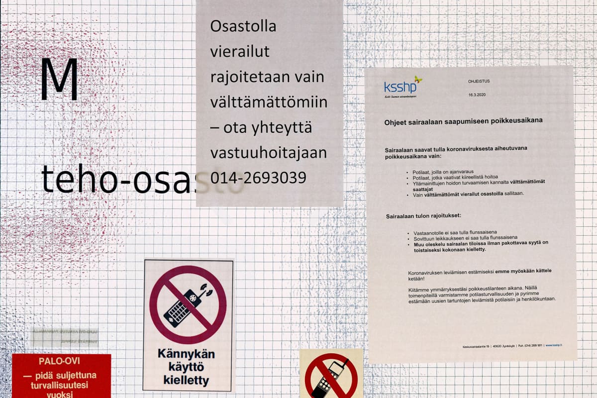Liikkumisrajoituksia koskevia ilmotuksia teho-osaston ovessa Keski-Suomen keskussairaalassa.