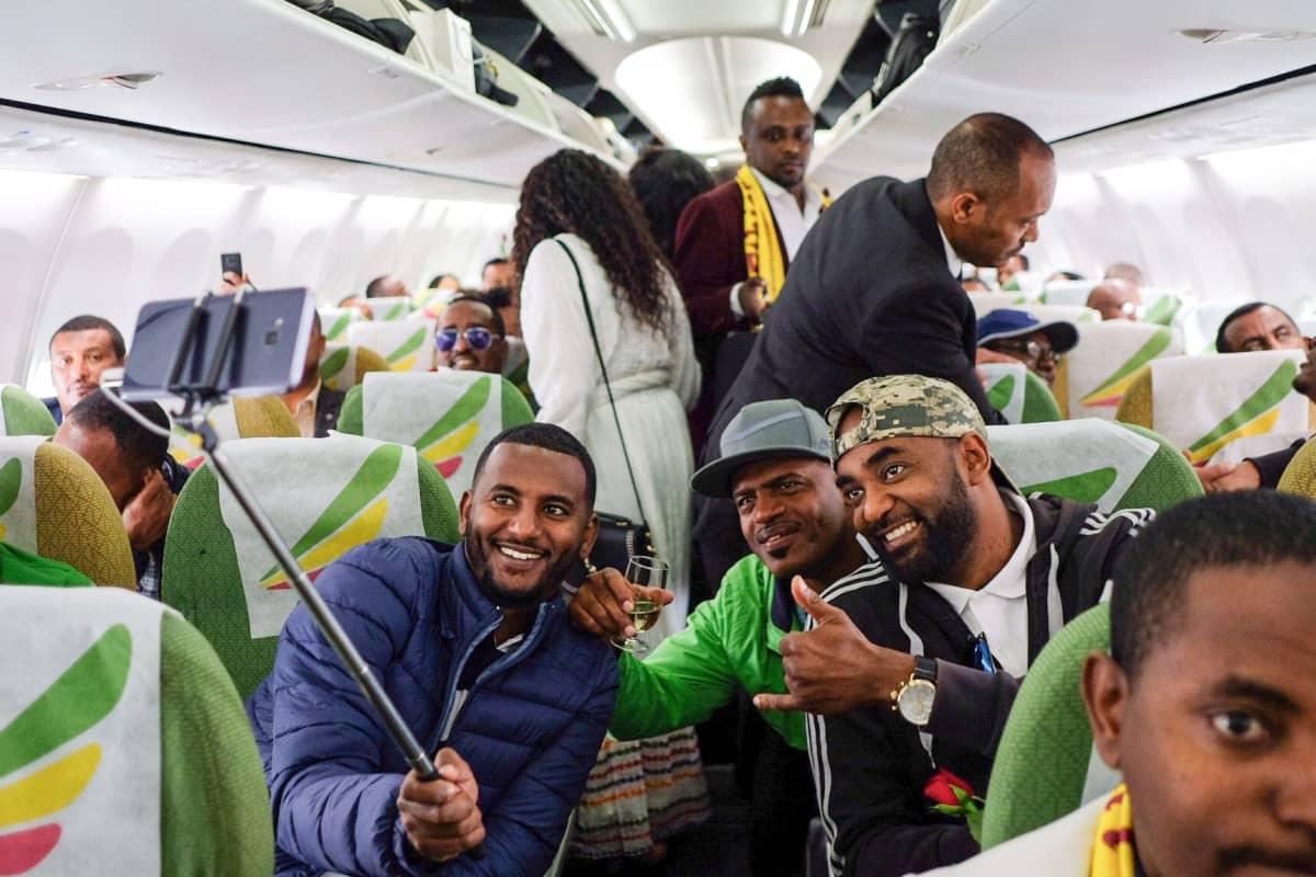 Matkustajat ottavat selfieitä lentokoneessa.