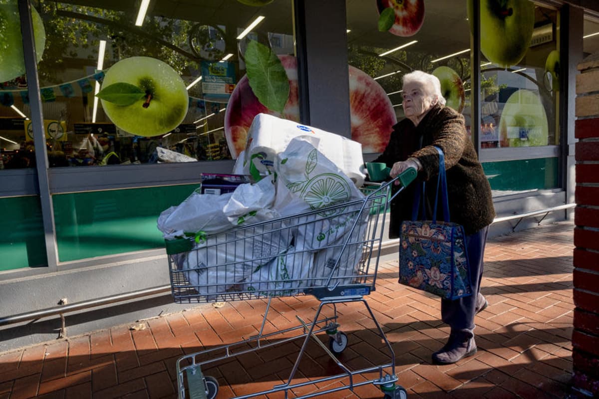 Nainen työntää ostoskärryjä täynnä ostoksia