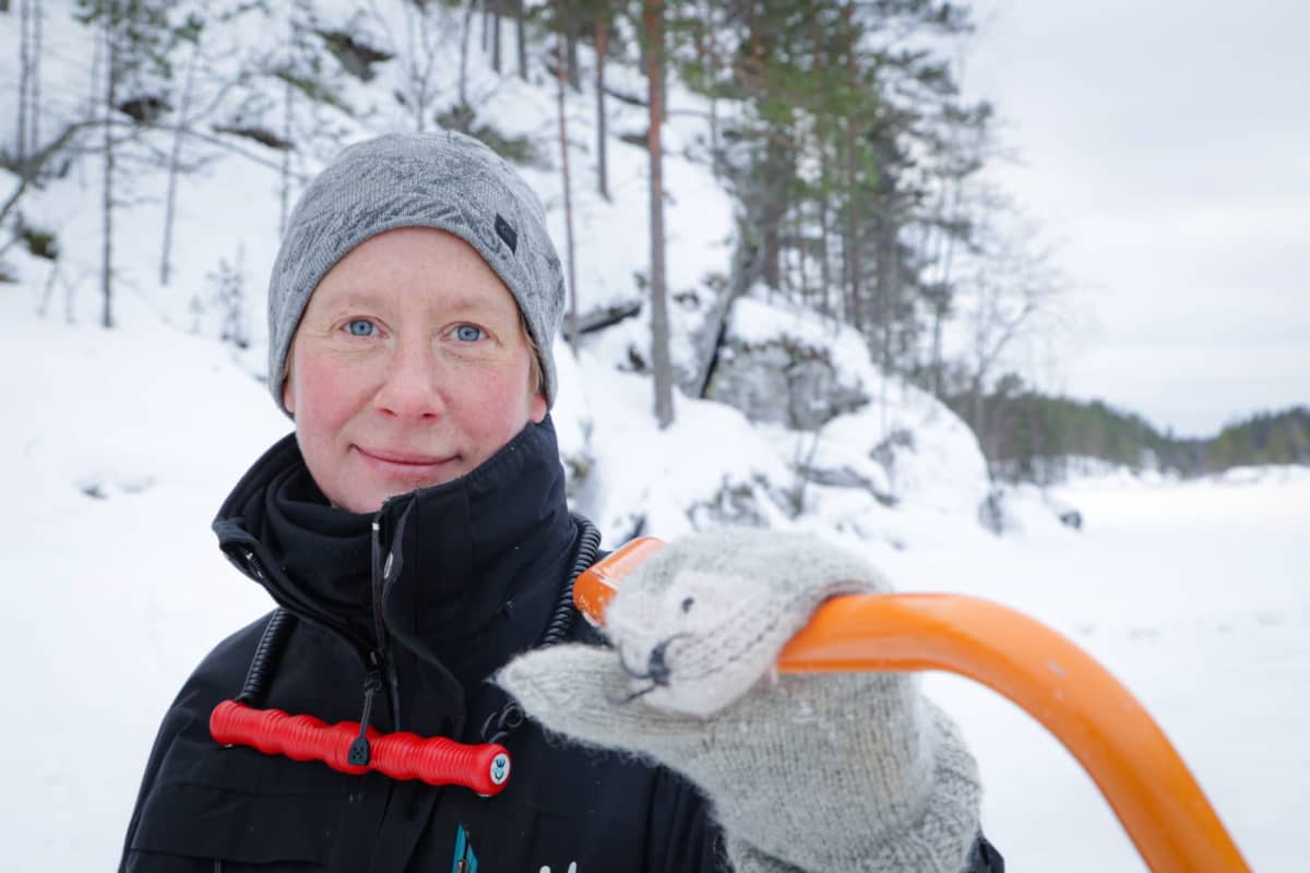 Metsähallituksen erikoissuunnittelija Miina Auttila nojaa lumikolaan Saimaan rantajäällä.