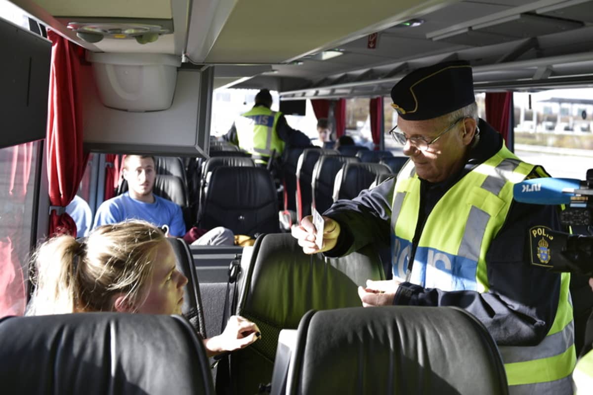 Poliisi katsoo naisen henkilöllisyystodistusta junassa Ruotsin ja Tanskan rajalla.