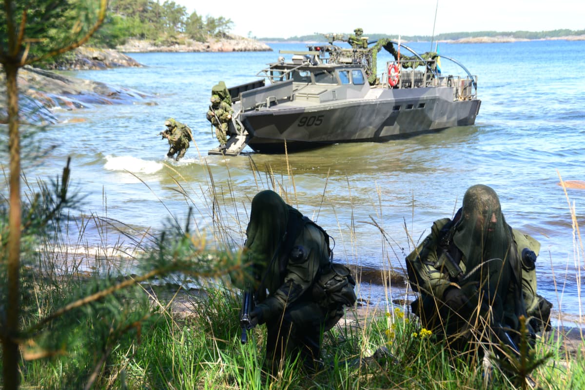 militär personal under övning vid strand