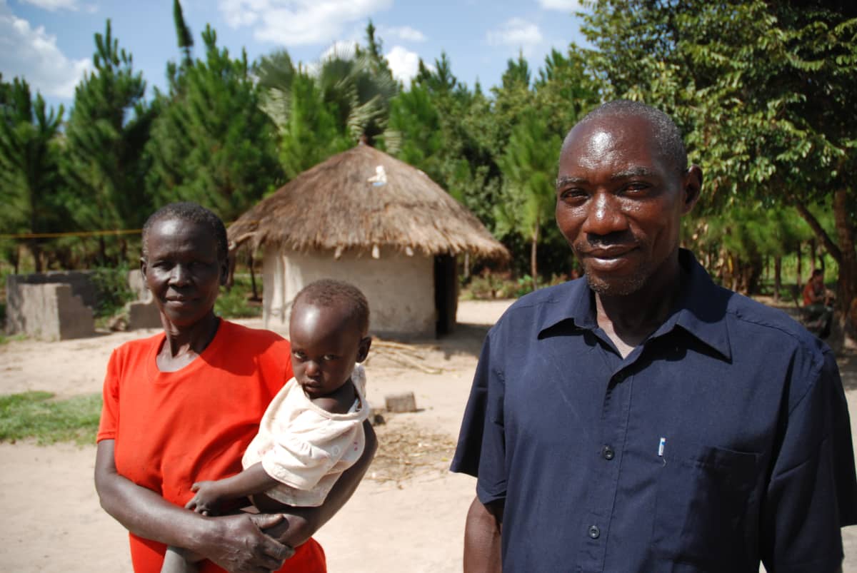 Ugandalainen Maxwell Oninje vaimonsa ja lapsensa kanssa.