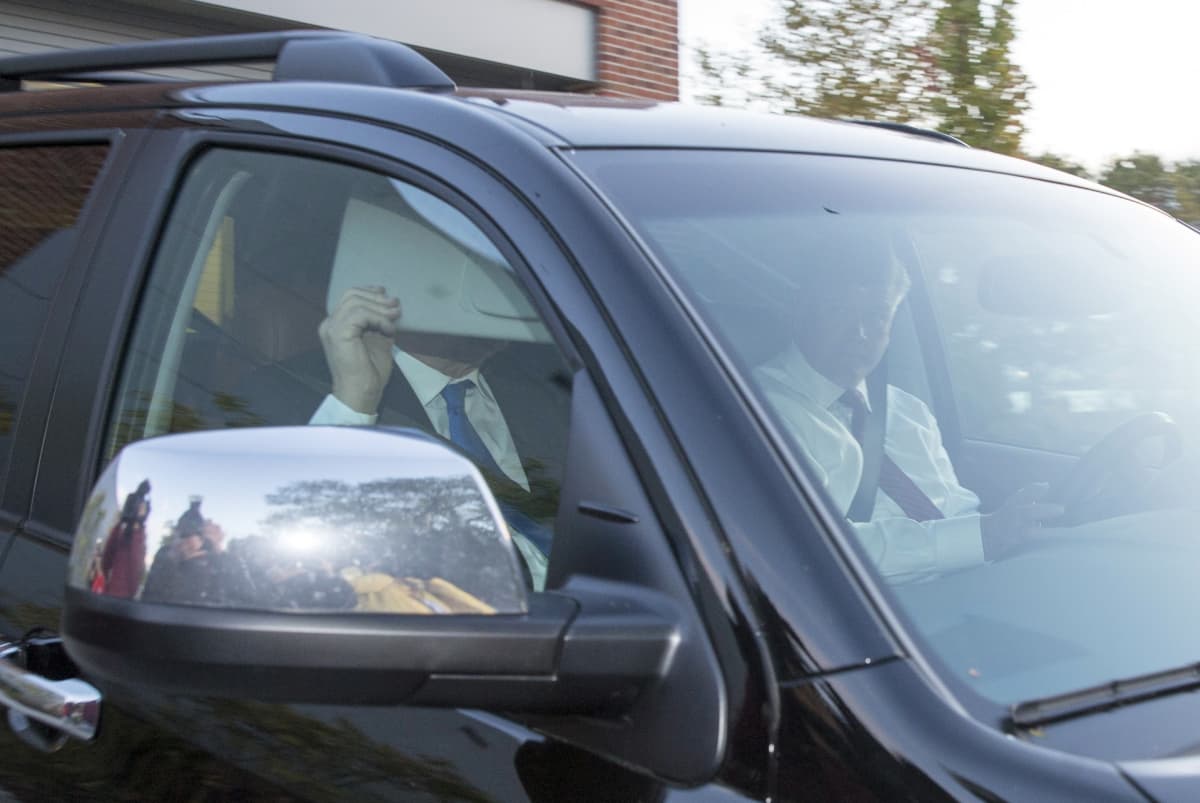 Paul Manafort peittää kasvonsa lähtiessään autolla kotoaan ilmoittautuakseen poliisille.