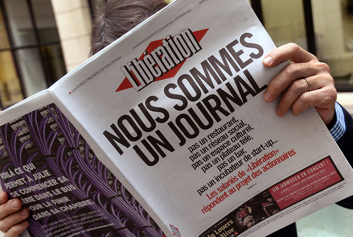 Mies lukee Libération-sanomalehteä.