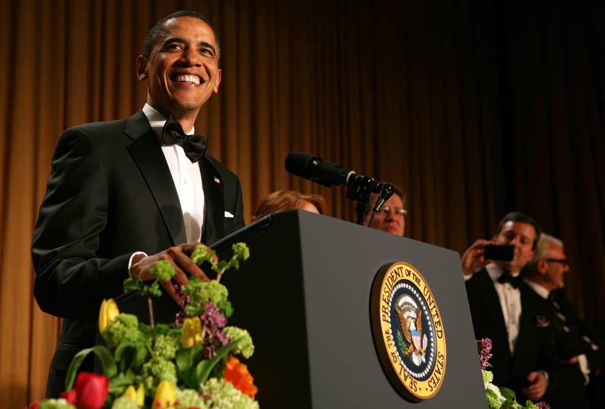 Presidentti Barack Obama puhuu Valkoisen talon kirjeenvaihtajayhdistyksen gaalaillallisilla. Obama hymyilee leveästi. 