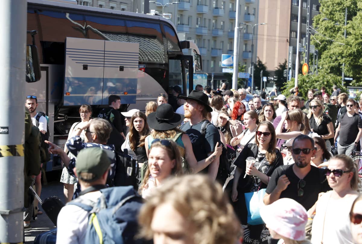 Ihmisiä jonottamassa bussien kyytiin.