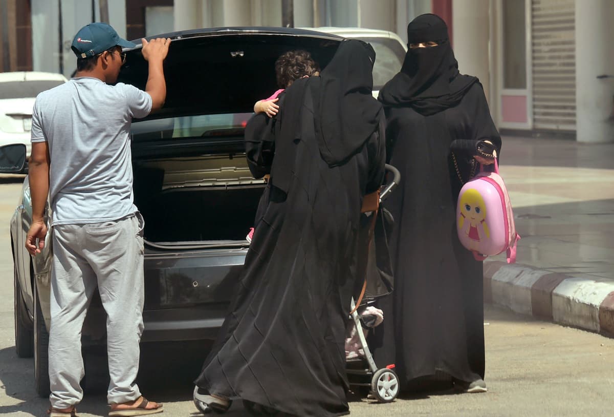 Naiset ottamassa lastenrattaita ulos autosta ostoskeskuksen parkkipaikalla Riadissa 27. syyskuuta.