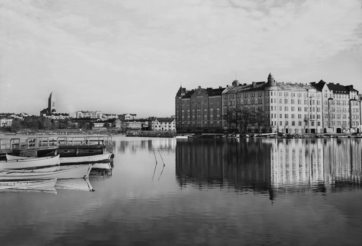 Tuntematon kuvaaja ikuisti Pitkänsillanrannan näkymän vuonna 1920. Miljoonaomaisuuden saanut taloyhtiö sijaitsee katujen kulmassa.