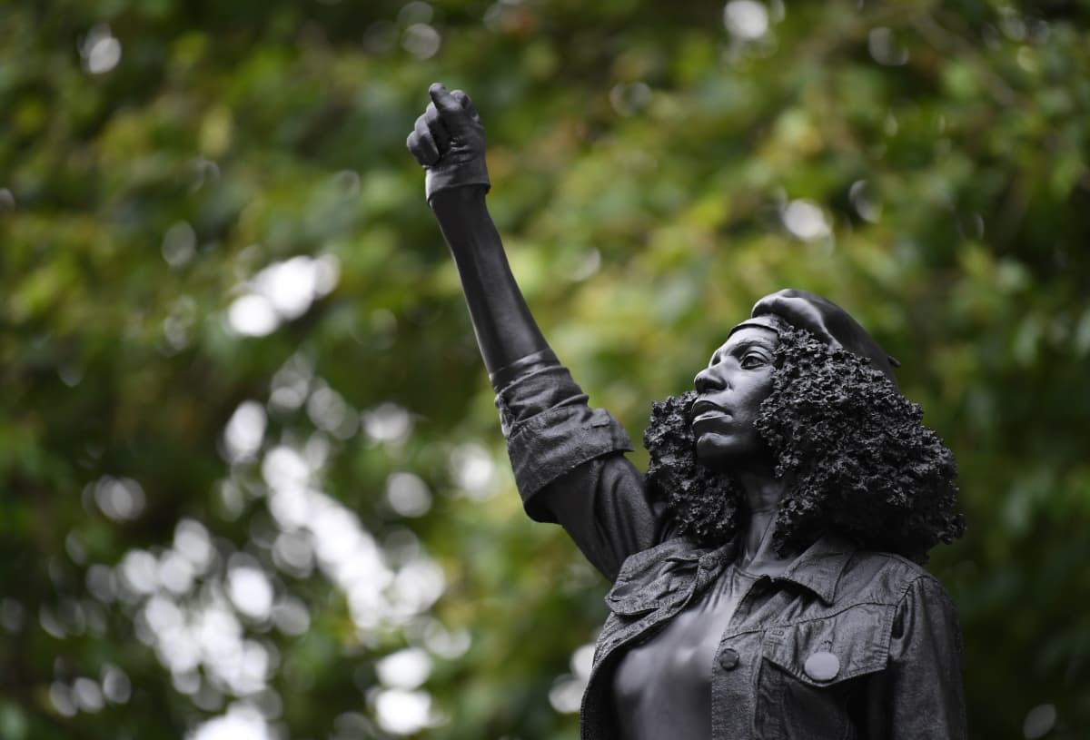 Mustaa naista esittävä patsas. Naisen käsi on nyrkissä.