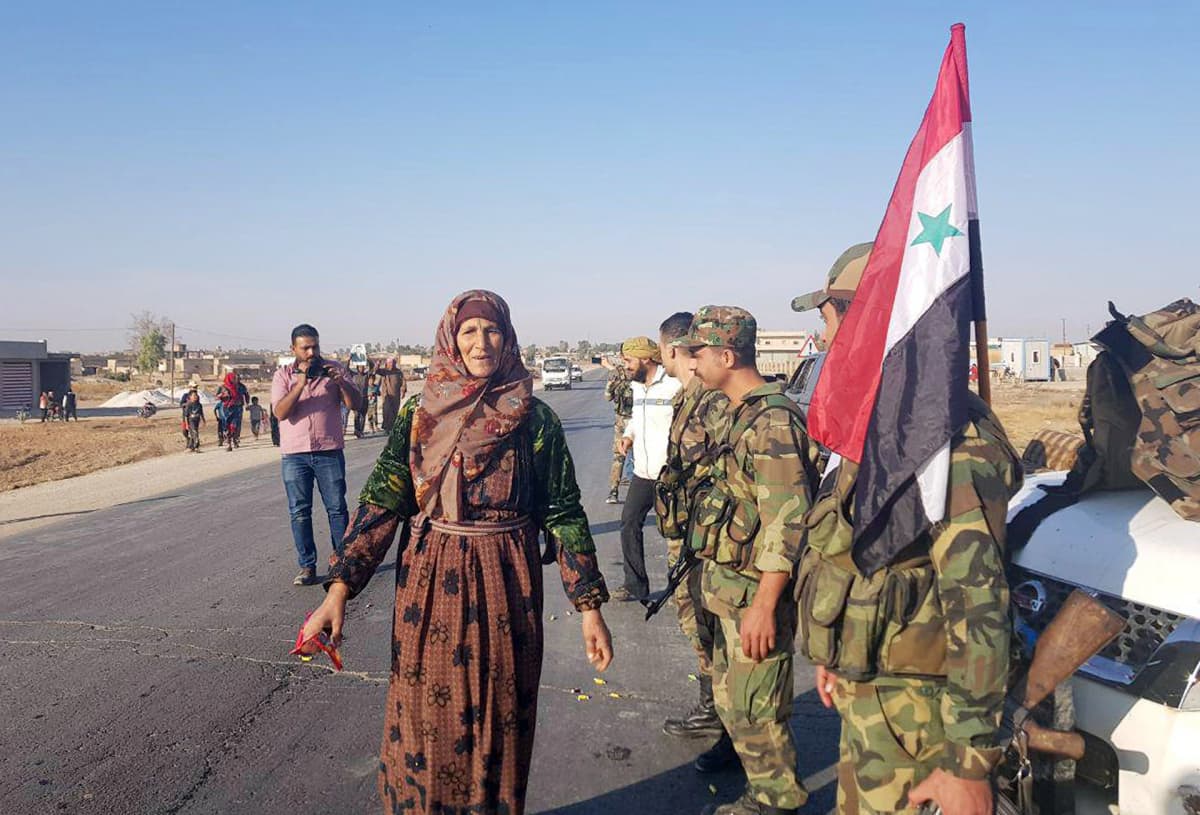 Siviilit tervehtivät Syyrian hallinnon joukkoja Tal Tamr -kaupungissa 14.10.