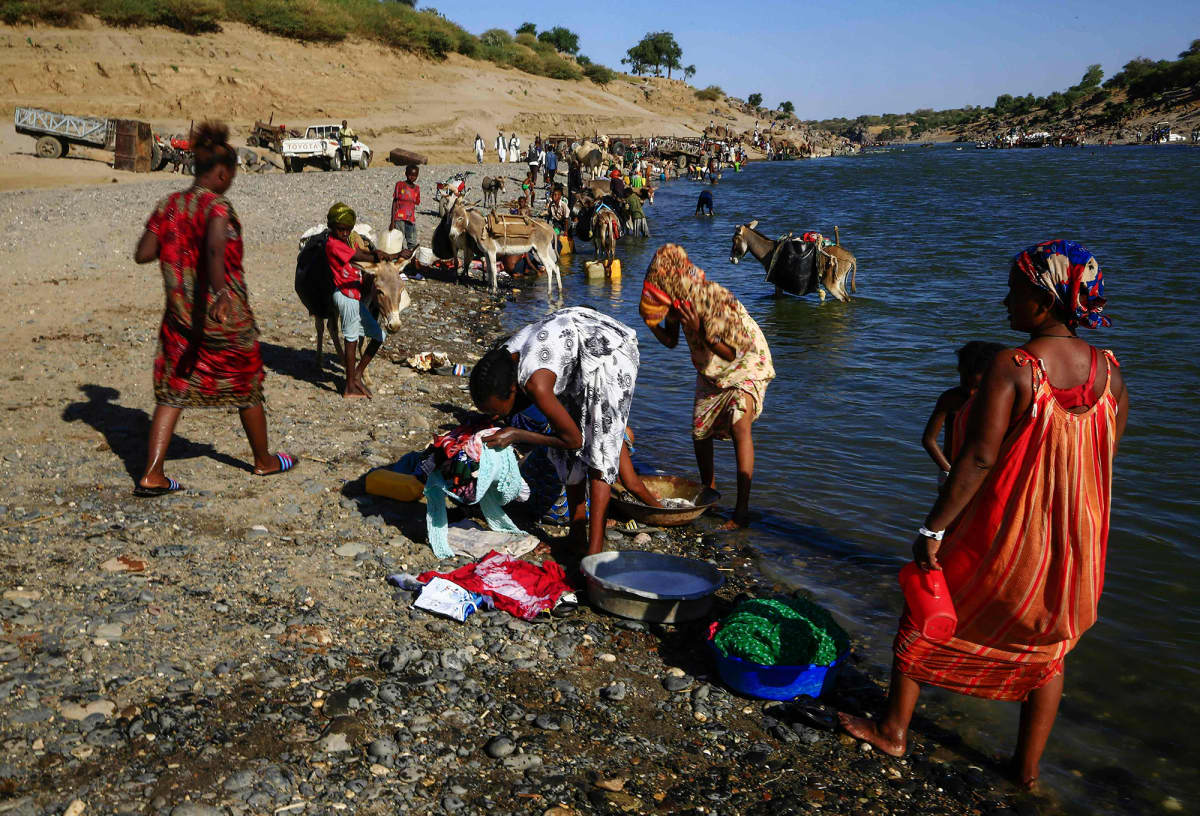 Pakolaiset peseytyvät joessa.