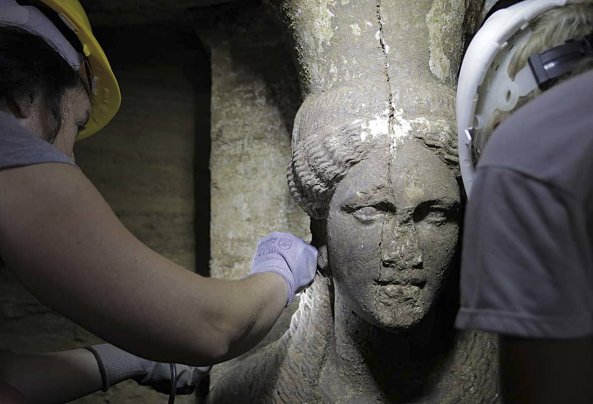 Arkeologeja tutkimassa karyatidin kasvoja.