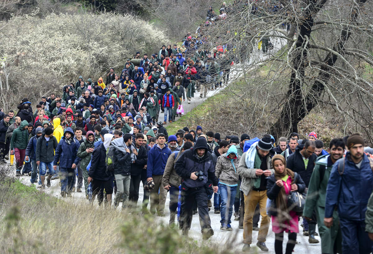 Tuhansia pakolaisia kävelee kreikkalaisen Idomenin kylän leiriltä kohti Makedonian rajaa 14. maaliskuuta.