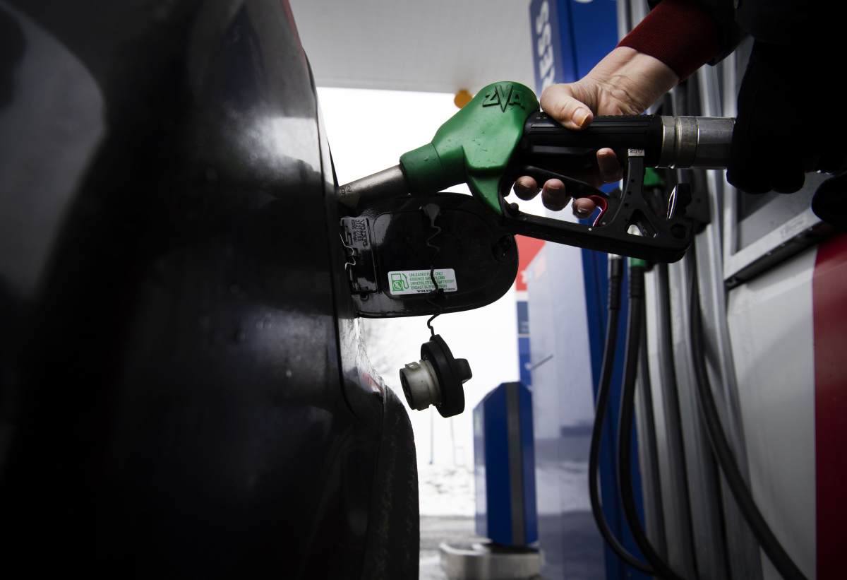 Henkilö tankkaa autoa.