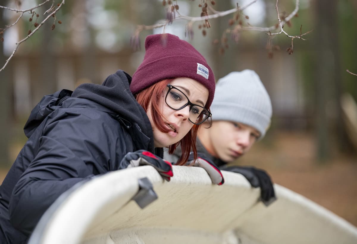 Nuorisotyöntekijä Anni Tahvanainen auttamassa nuoria veneen pesussa.