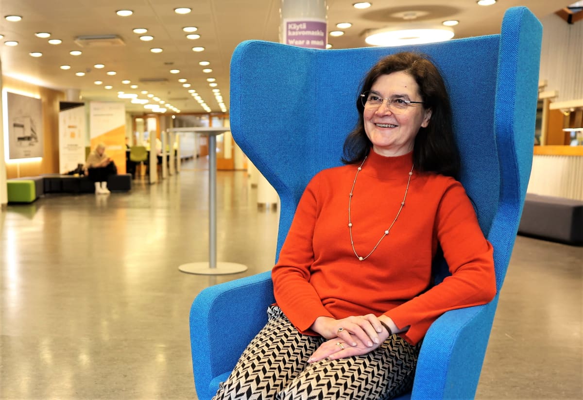 Väitöstutkija Outi Köhler istuu nojatuolissa Turun Kauppakorkeakoulun aulassa