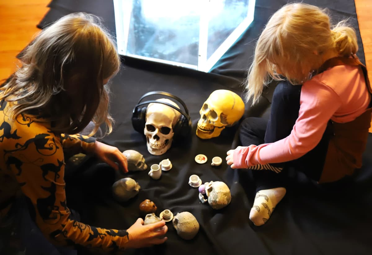 Taiteilija Ilmari Wärrin tyttäret leikkivät pääkalloilla.
