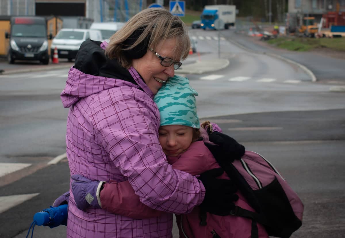 Seija Vahvelainen halaa lapsenlastaan ulkona tämän lähtiessä kouluun.