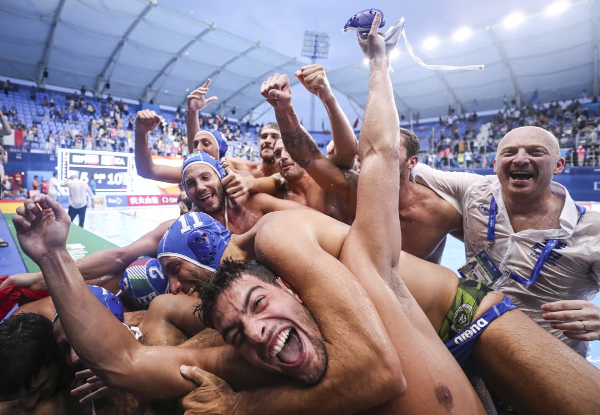 Italian vesipallojoukkue juhlii kultamitaliaan halaamalla ja hyppimällä toisetensa päälle.
