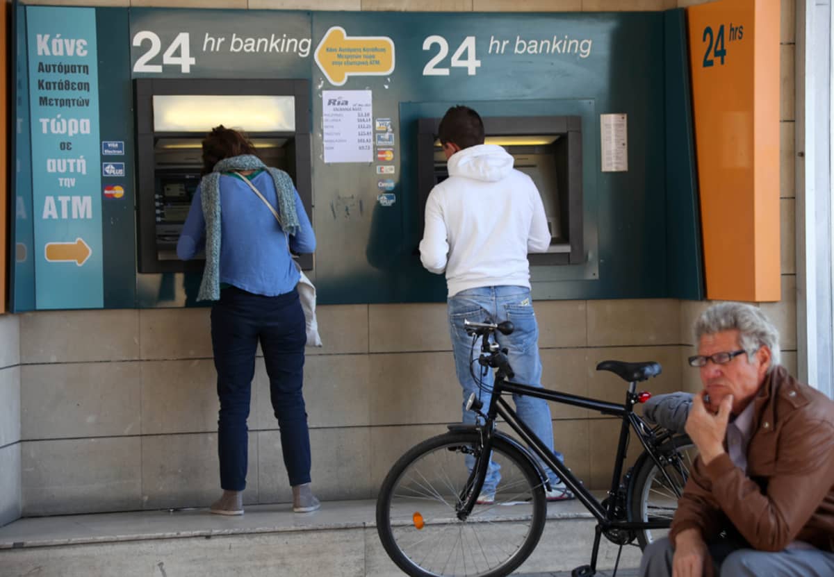 Kyproslaiset nostavat käteistä rahaa automaateista.