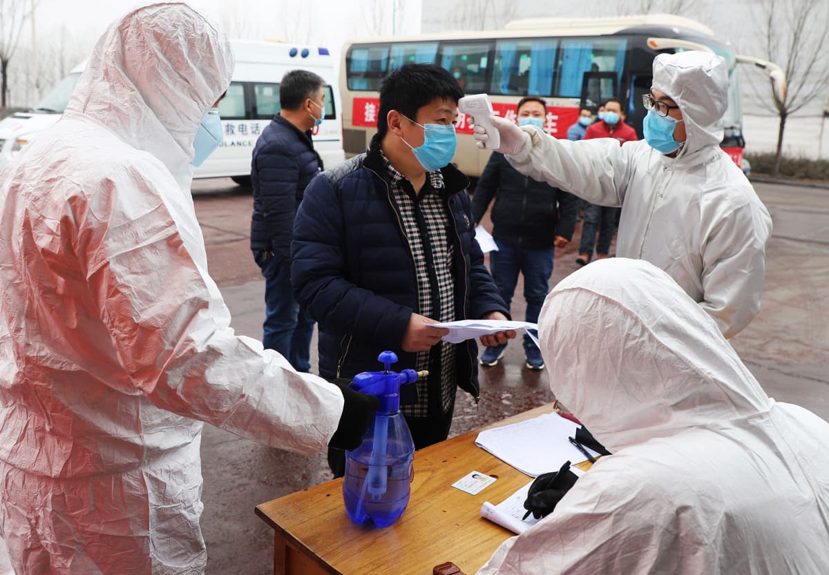 Kiinassa Shandongin maakunnassa mitataan työntekijän lämpötilaa helmikuun lopulla.