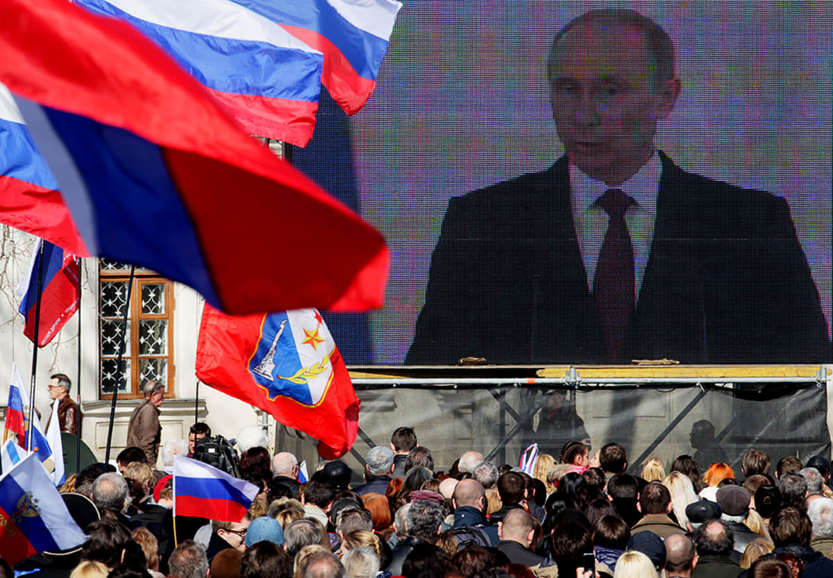 Väkijoukko seuraa Vladimir Putinin puhetta suurelta videonäytöltä Sevastopolissa.
