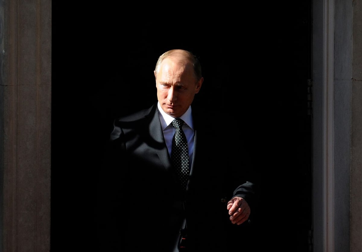 Vladimir Putin mustaa taustaa vasten. Aurinko valaisee Putinin kasvojen toisen puolen, toinen on varjossa.