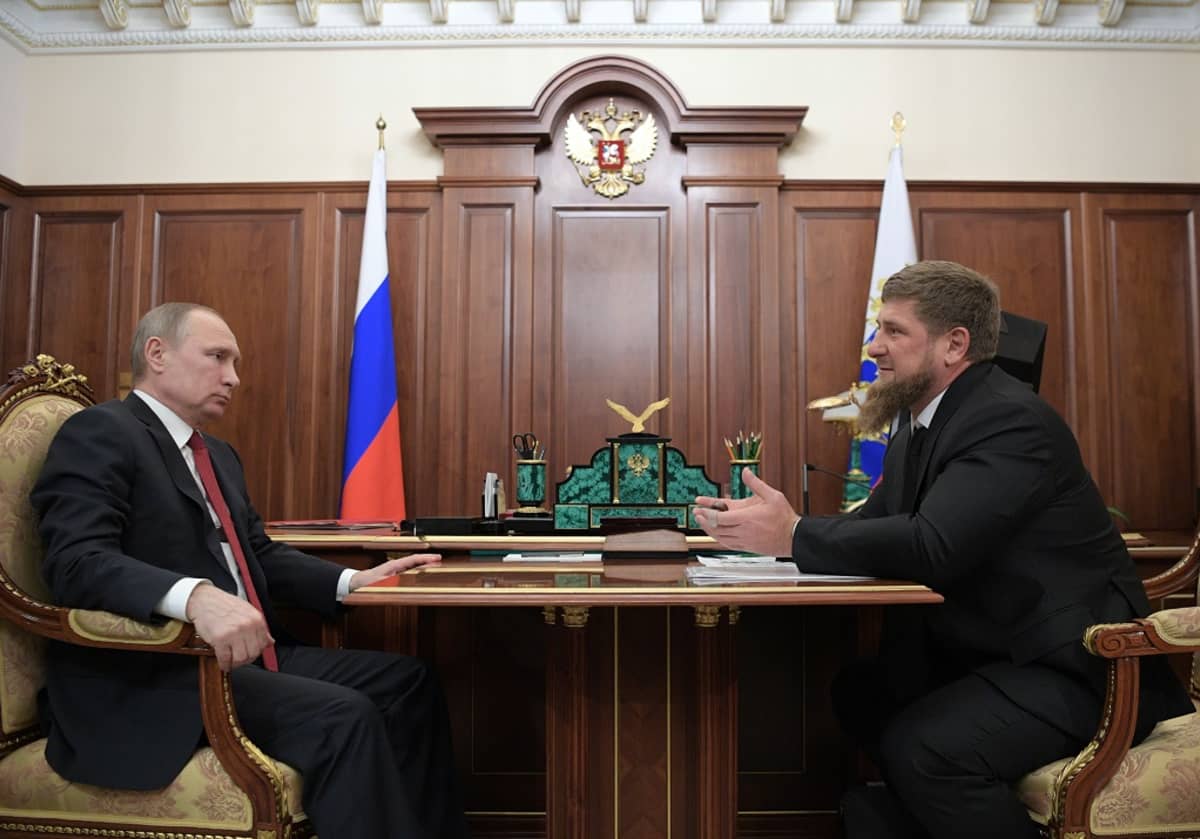 Putin ja Kadyrov istuvat vastakkain presidentin työhuoneessa kirjoituspöydän edessä olevan pienemmän pöydän äärellä. Parrakas Kadyrov selittää juuri jotain käden eteen ojennettuina. Putin kuuntelee vakava ilme kasvoillaan. Taustalla seinän luona on Venäjän lippu ja seinäpaneelissa Venäjän vaakuna, kaksipäinen kotka.