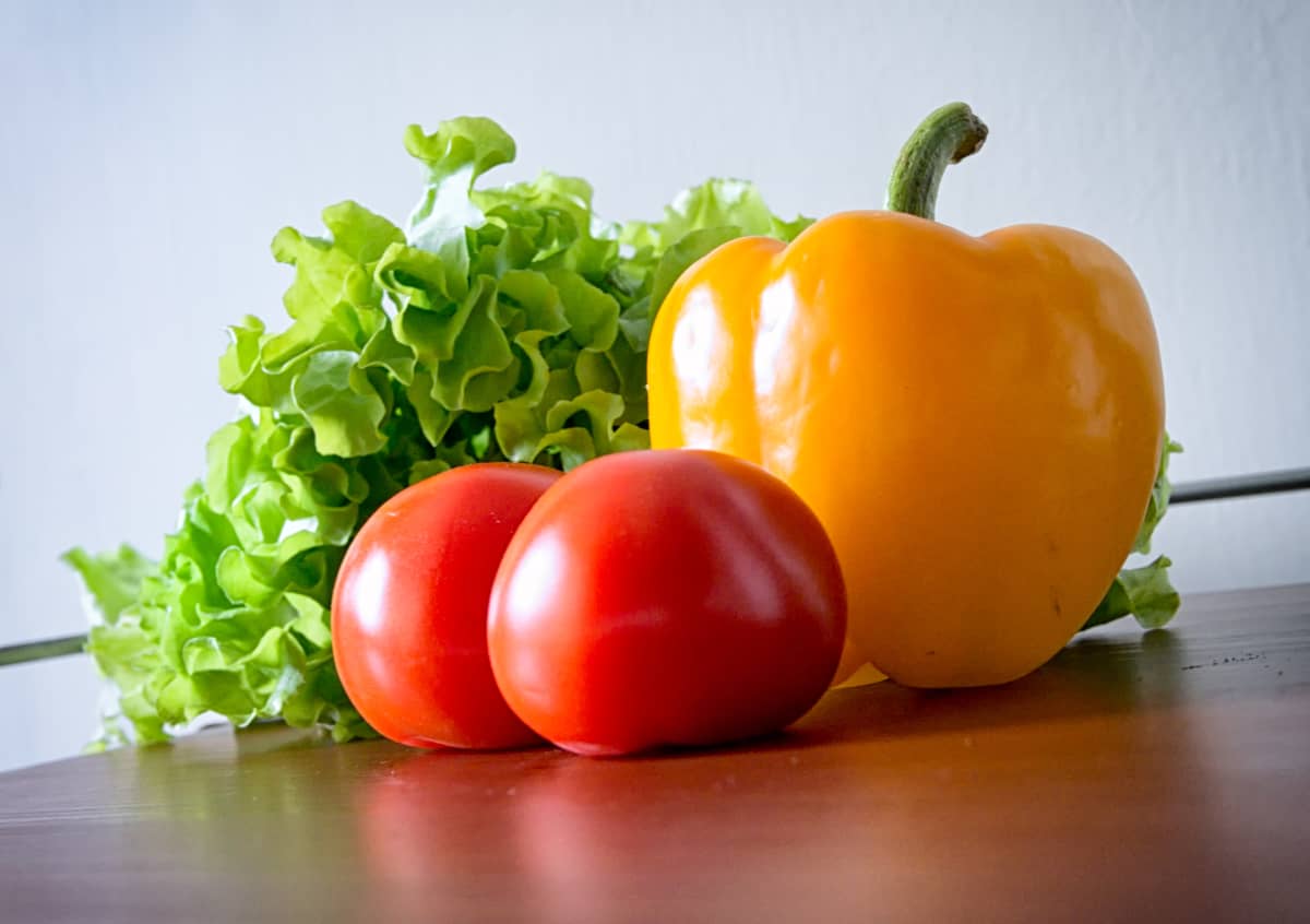 Salaattia, paprika ja tomaatteja pöydällä