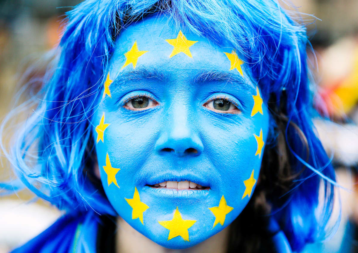 Eu:n lippu maalattuna nuoren naisen kasvoihin.