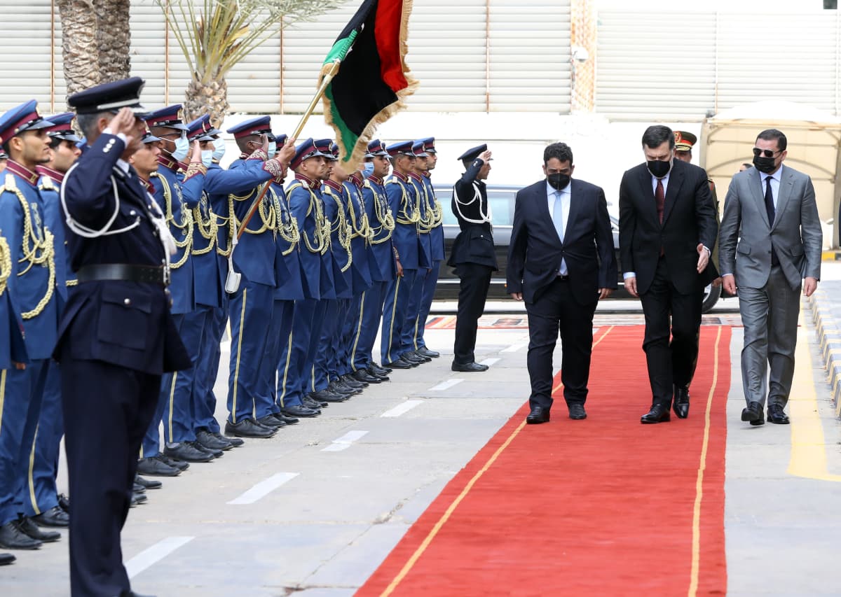 Libyan presidenttineuvoston uusi päällikkö Mohamed al-Menfi (vasemmalla), väistyvä pääministeri pääministeri Fayez al-Sarraj (keskellä) sekä väliaikaishallituksen pääministeri  Abdul Hamid Dbeibah (oikealla) Tripolissa järjestetyissä virkaanastujaisissa.