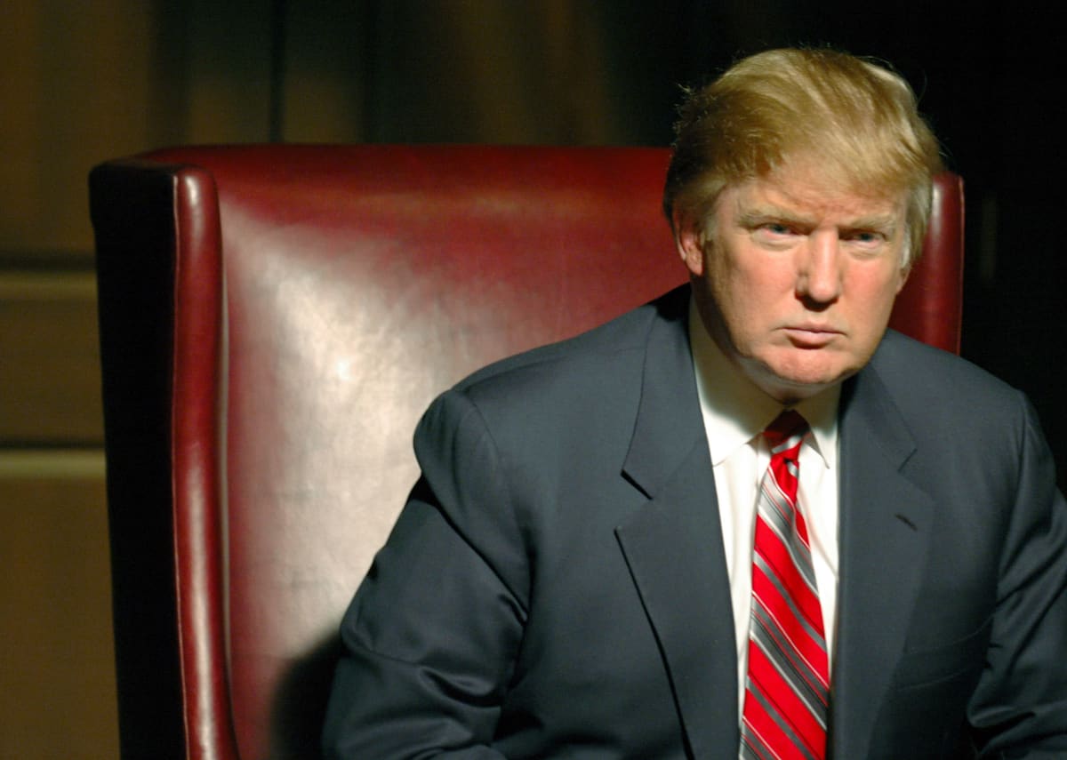 Donald Trump istuu tuimailmeisenä näyttävässä tuolissa tositv-sarjassa Diili.