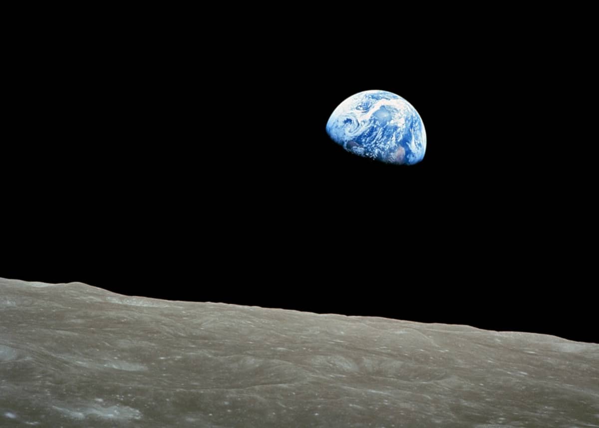 Maapallo avaruuden pimeydessä, edessä Kuun kamaraa. 