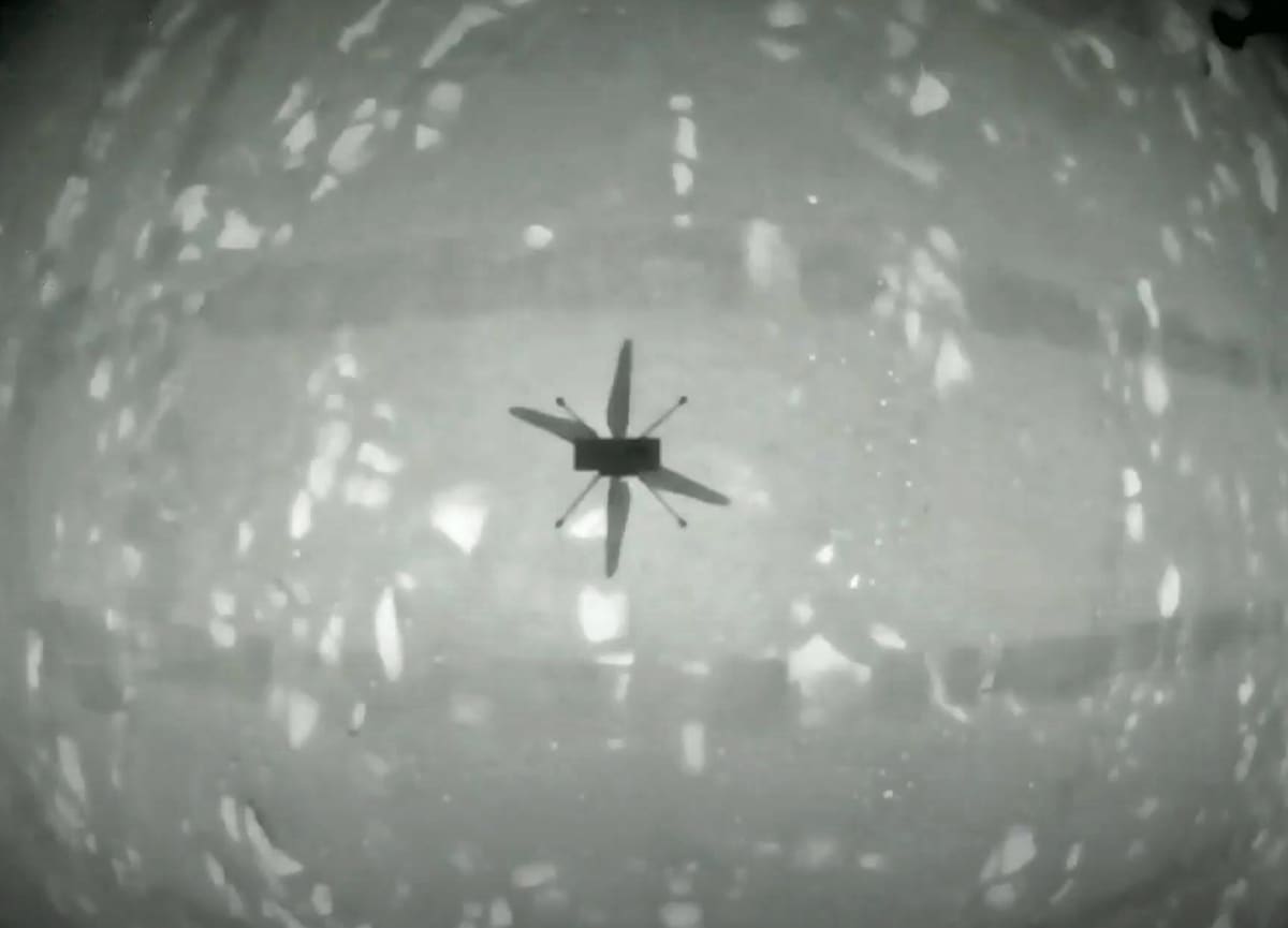 Mustavalkoinen kuva pienen helikopterin varjosta kaarevalla pinnalla. 