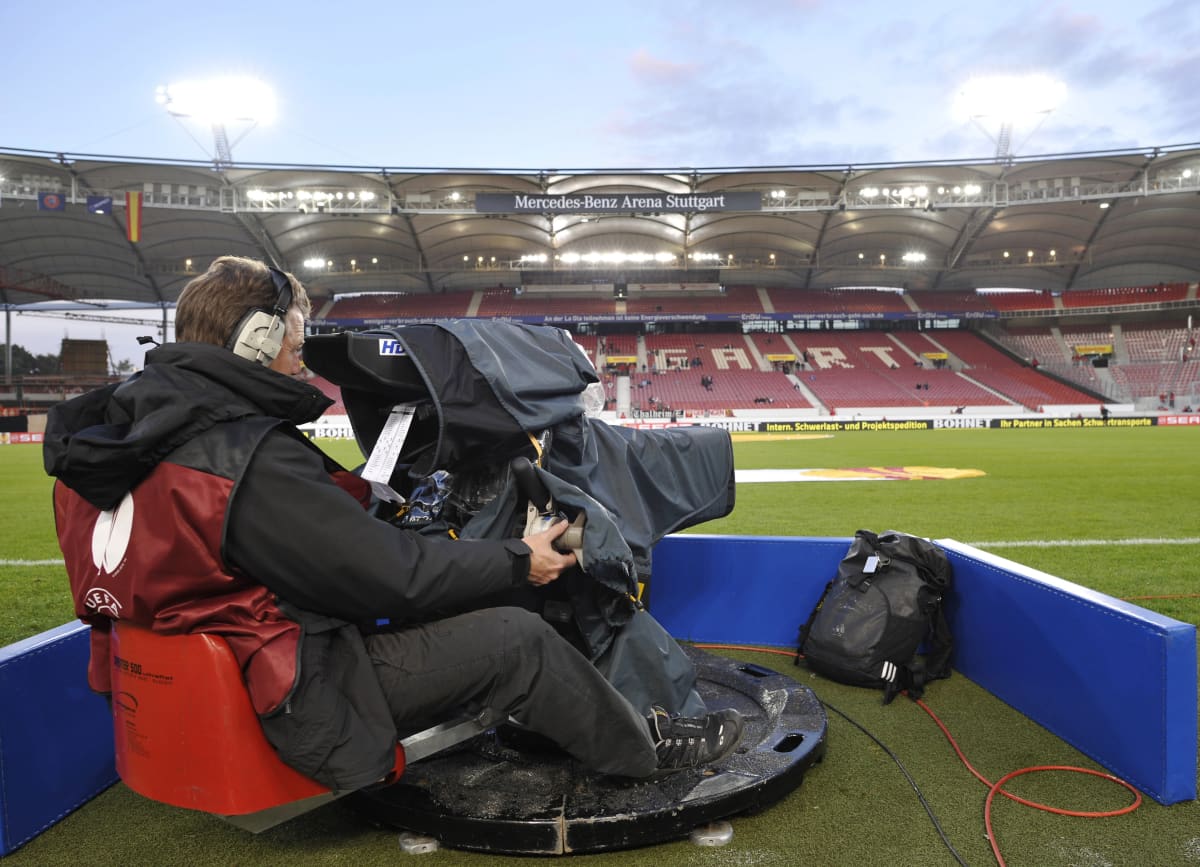 Tv-kameramies stadionilla valmiina kuvaamaan.