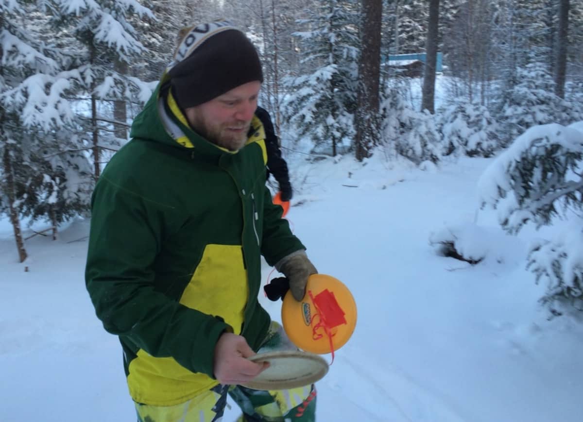 Mikko Pulkkinen ja frisbee talvisessa metsässä.