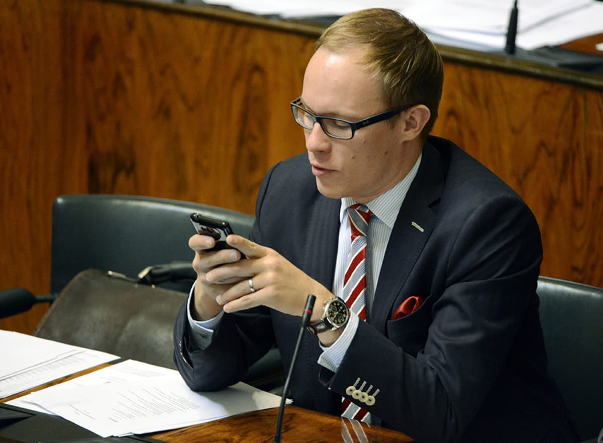 Kokoomuksen kansanedustaja Lasse Männistö käyttää matkapuhelintaan eduskunnan täysistunnossa Helsingissä 27. syyskuuta 2013.