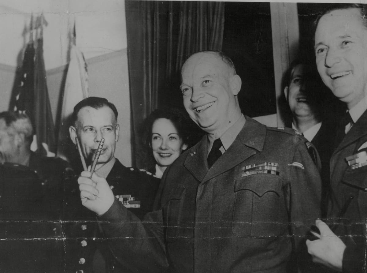 Eisenhower pitää kahta kynää kädessään v-muodossa