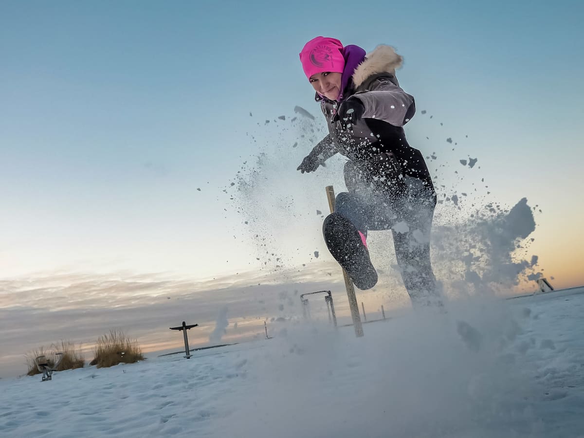 Oululainen Netta Brandt potkaisee lunta kameraa kohti